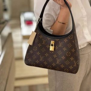 *Louis Vuitton*
The Drop PM

Details 
28 x 15 x 12 cm
(Length x Height x Width)
Monogram coated canvas
Cowhide-leather trim
Microfiber lining
Gold-toned finish
Magnetic closure
1 interior small flat pocket
1 secret front pocket with secure closure
1 leather name tag with padlock
Fits: 6.7-inch smartphone, Zippy Long wallet, earphones, keys, lipstick
Strap: removable, adjustable
Handle: Double
Includes brand double box & dust bag